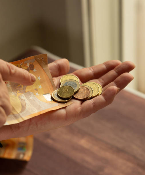 woman's hands with loose euro coins to pay in cash - women savings uk coin imagens e fotografias de stock