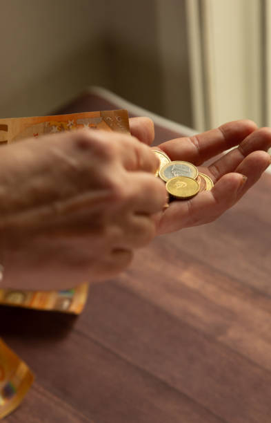 woman's hands with loose euro coins to pay in cash - women savings uk coin imagens e fotografias de stock