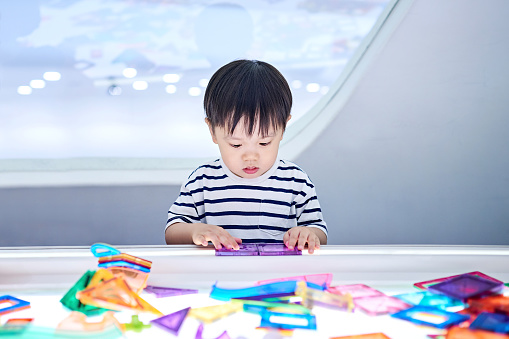 Close-up of one cute little boy playing with magnetic constructor.
