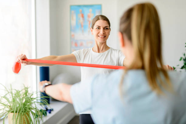 istock Modern rehabilitation physiotherapy woman worker with woman client using elastic 1397056637