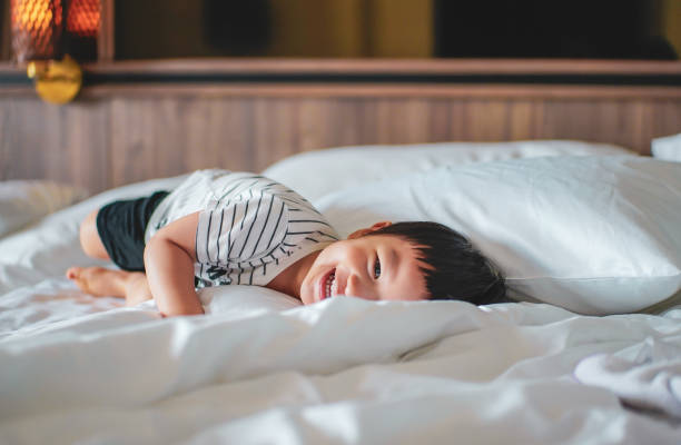 istock Little boy feel relax and laydown on the bed with smiling face. 1397057517