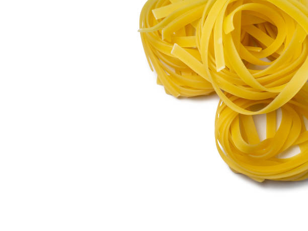 istock Pasta nests on a white background. Culinary background. Curled pasta on the table. Uncooked product.  Product made from flour and dough. Background from noodles. 1397057553