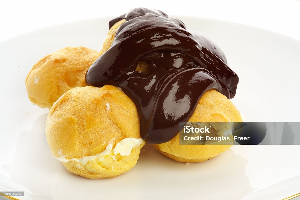 Fresh profiteroles with hot chocolate sauce Fresh profiteroles with hot chocolate sauce, just poured. Baked Pastry Item Stock Photo