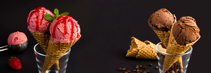 Colorful ice cream scoops in paper cups with berries on wooden table