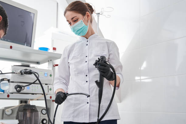 Female doctor gastroenterologist with probe to perform gastroscopy and colonoscop Waist up portrait view of the female doctor gastroenterologist with probe to perform gastroscopy and colonoscopy. Gastroscopy concept colonoscopy stock pictures, royalty-free photos & images