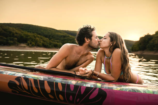 istock Happy couple paddlelboarding in lake at sunset 1397060886