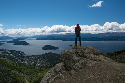 A man looks at the landscape in San Carlos de Bariloche. a city in the Argentinian province of Rio Negro. It is called Bariloche for short. It is famous for skiing, sightseeing, water sports, and trekking and climbing.