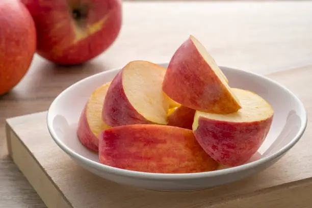 Photo of Fresh red apples sliced in white plate