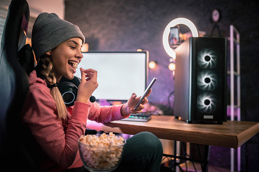 girl eating popcorn and looks at her phone