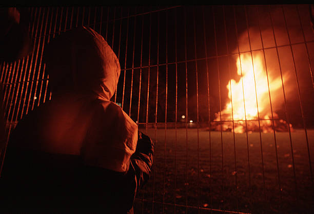 A child watches a bonfire set in celebration of Guy Fawkes Day in Ravenscourt Park, London, England.
