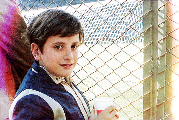 Vintage portrait of a boy at a soccer game in the stadium. Very grainy analog image from the seventies.