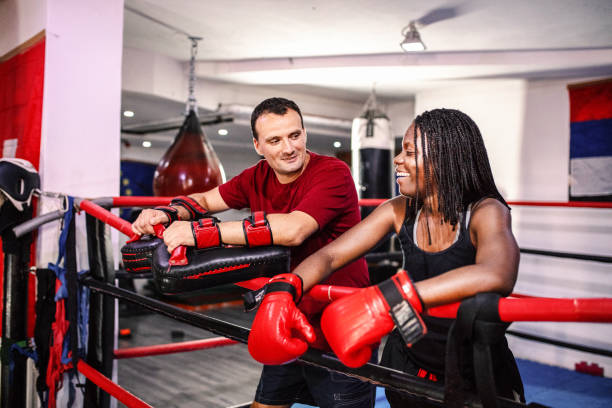 istock Female boxer relaxing with her trainer in the ring 1397067527