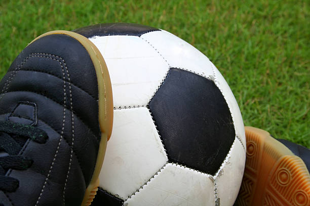 A soccer ball and a pair of shoes stock photo