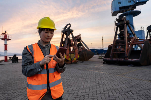 istock A female worker uses a mobile phone at a shipping port 1397068748
