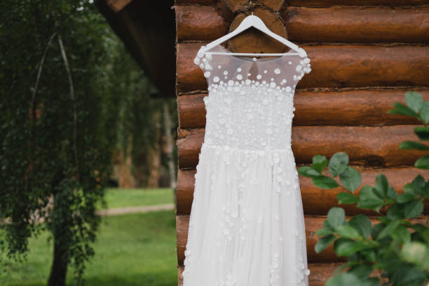 istock White wedding dress hanging on a tree outdoors in the garden. 1397070342