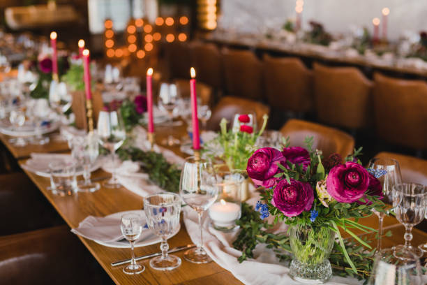 istock Table setting at the wedding reception. Floral compositions with beautiful ranunculus flowers and greenery, candles, laying and plates on a decorated table. 1397071063