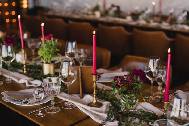 istock Table setting at the wedding reception. Floral compositions with beautiful ranunculus flowers and greenery, candles, laying and plates on a decorated table. 1397071074