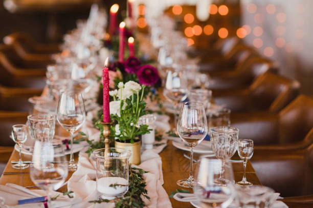 istock Table setting at the wedding reception. Floral compositions with beautiful ranunculus flowers and greenery, candles, laying and plates on a decorated table. 1397071077