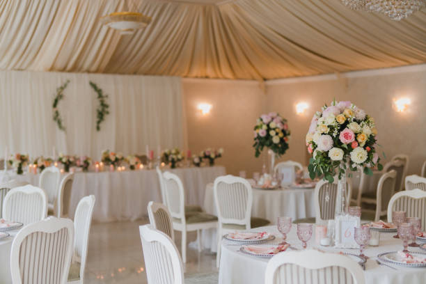 istock Table setting at the wedding reception. Floral compositions with beautiful flowers and greenery, candles, laying and plates on a decorated table. 1397071175