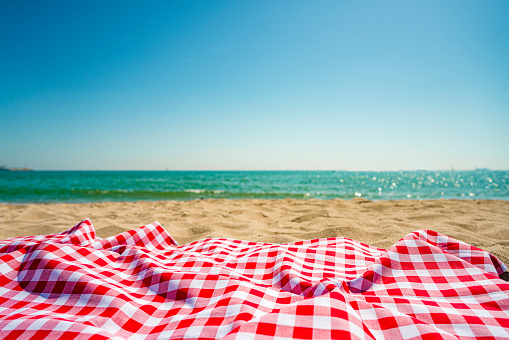 red and white checkered picnic blanket on beach sand. High resolution 42Mp outdoors digital capture taken with SONY A7rII and Zeiss Batis 40mm F2.0 CF lens