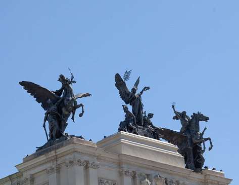Madrid, Spain - 25th April 2022. La Gloria y los Pegasos, the Glory and the Pegasus, a bronze allegorical sculpture in three sets of three figures, on top  of the Ministry of Agriculture building in Madrid. It is a 1976 copy by Juan de Avalos of the 1905 original marble sculpture designed by Agustín Querol Sibirats.