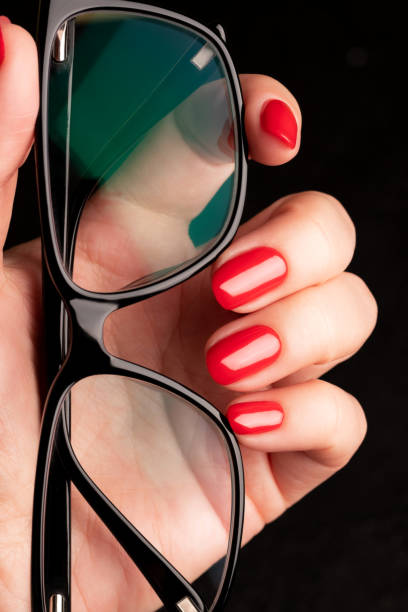 istock Hand with red nails and glasses 1397074794