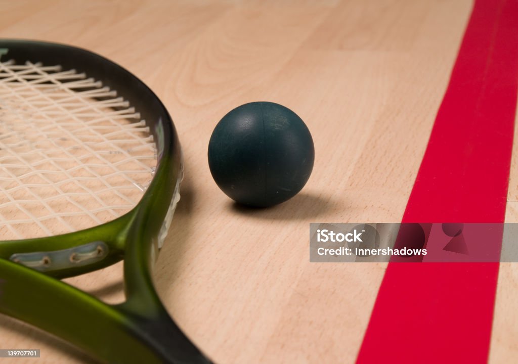Squash ball and racket Squash ball and racket next to a red line. Racketball Stock Photo