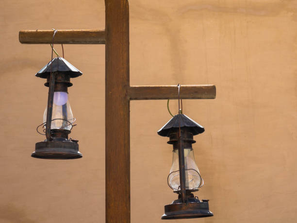 istock Two lanterns hang from a wooden pole against brown wall. Close up 1397077094