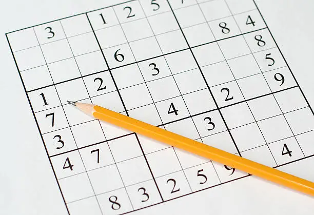 sudoku puzzle and yellow pencil