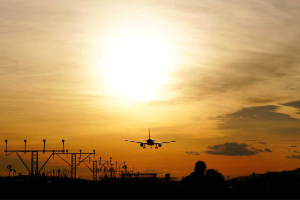 A plane landing at sunset A plane landing at sunset with couple watching at it chico california photos stock pictures, royalty-free photos & images