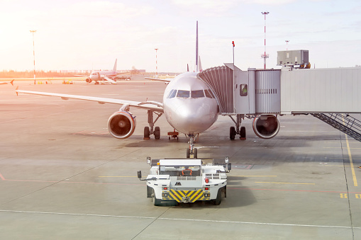 Departure of the airplane from the air bridge, towing and launch jet engine in progress