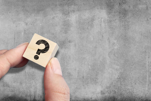 Question mark on wooden block with copy space on concrete wall background