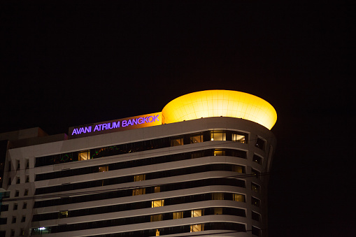 Illuminated modern building in Bangkok at night. Name of building is Avani Atrium Bangkok