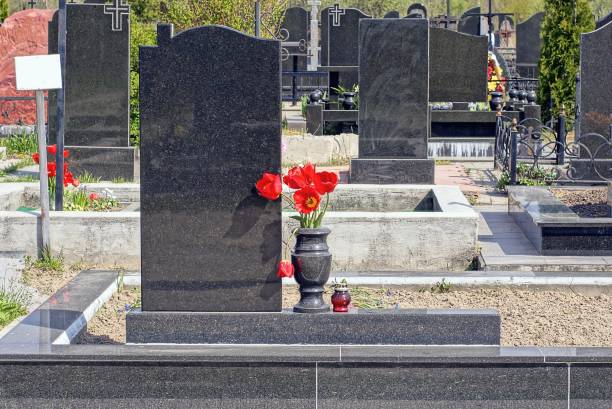 un vaso di marmo nero con fiori rossi in un monumento di granito - camposanto monumentale foto e immagini stock