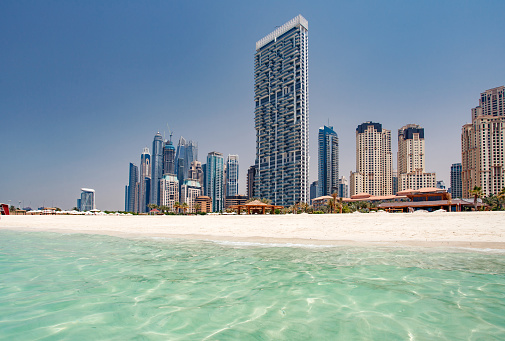 Dubai, UAE - April 21, 2022: One JBR Tower, Dubai Marina, beach and turquoise waters of Persian Gulf.