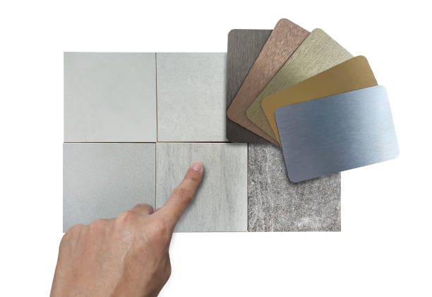 istock designer's hand choosing interior material samples including various color of metallic laminateds and various texture of grey stone tiles isolated on background with clipping path. mood board. 1397082114