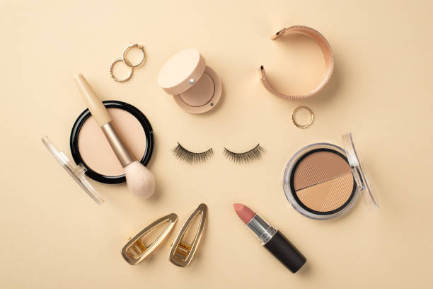 istock Make up concept. Top view photo of circle composition false eyelashes lipstick compact powder brush contouring palette eyeshadow gold wristlet rings and barrettes on pastel beige background 1397086250