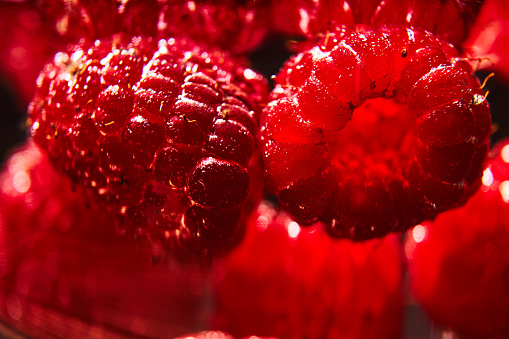 Fresh raspberries in a glass of water.