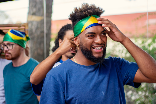 Black man putting Brazil bandana on forehead