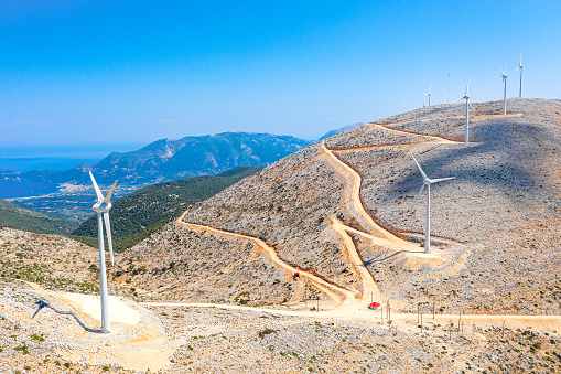 Ecology concept. Wind turbines in the mountains on the Kefalonia island, Greece. Aerial drone view.
