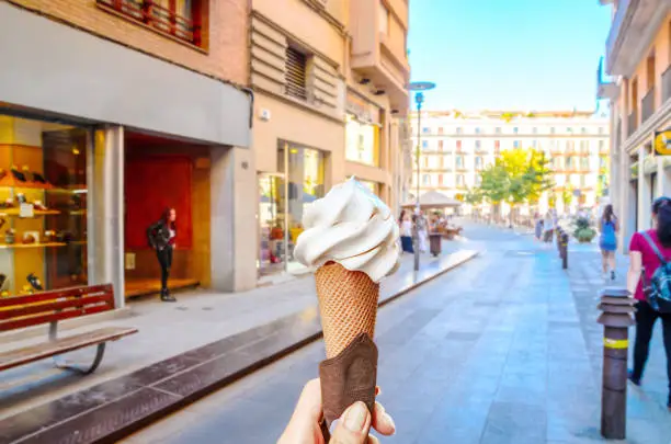 Photo of Woman hand holding ice cream waffle cone in the old town Girona, Catalonia, Spain