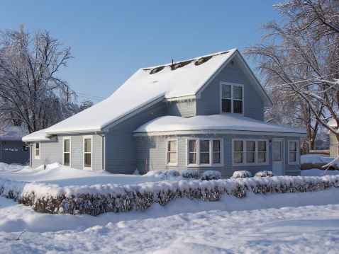 Beautiful Blue House Coated in a thick layer of Snow, trees coated in ice