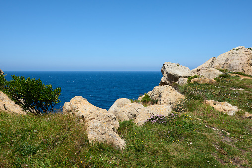 Whimsical rock formations with a turquoise blue sea and a beautiful blue sky.