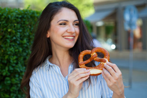 istock Young woman eating a pretzel 1397101963