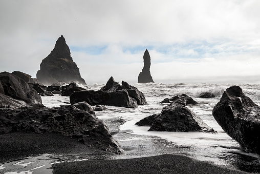 Beautiful seascape with the Reynisdrangar basalt sea stacks on the shoreline of Reynisfjara beach, near Vík í Mýrdal, Iceland