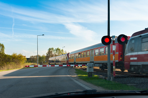 Train passing rail crossing viewed from inside of stopped car