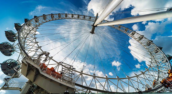 Lonon,England,UK-August 21 2019:Low angle view of the iconic London Eye,on the South Bank of the River Thames,as it slowly spins tourists around,on a sunny,warm summer day.