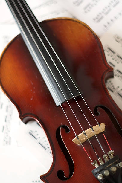 Violin Violin laying on sheet music. violin f hole stock pictures, royalty-free photos & images
