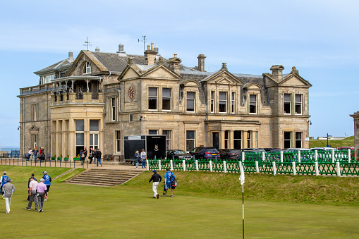 St. Andrews, Scotland, United Kingdom - April 28, 2022: View of the Royal and Ancient Gold Club of St Andrews clubhouse, near the first tee at the Old Course, with guests. St Andrews is the oldest golf course in existence.