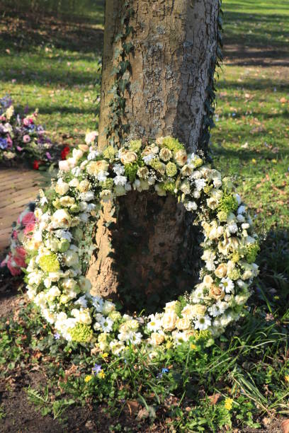 Sympathy wreath near a tree, various sorts of white flowers